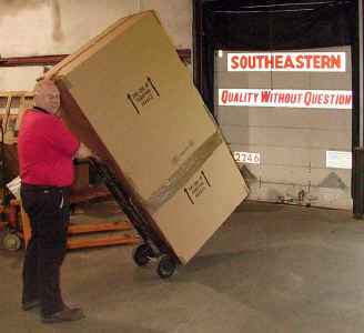 Freight line driver loading Grace wrought iron products onto truck