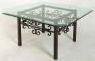 Gothic metal cocktail table with beveled glass top.